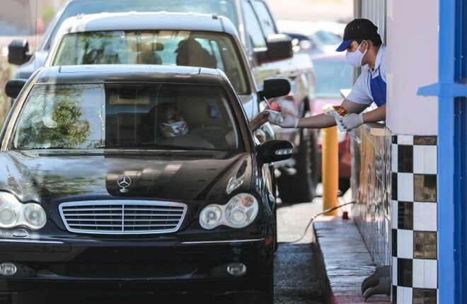 Customers wait a dozen cars deep in line to pick up on Thursday, Jan.