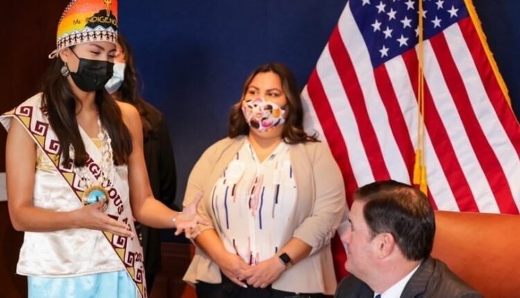 Lourdes Pereira stands next to Gov. Doug Ducey on Sept. 1 as he signs House Bill 2705, which preven...