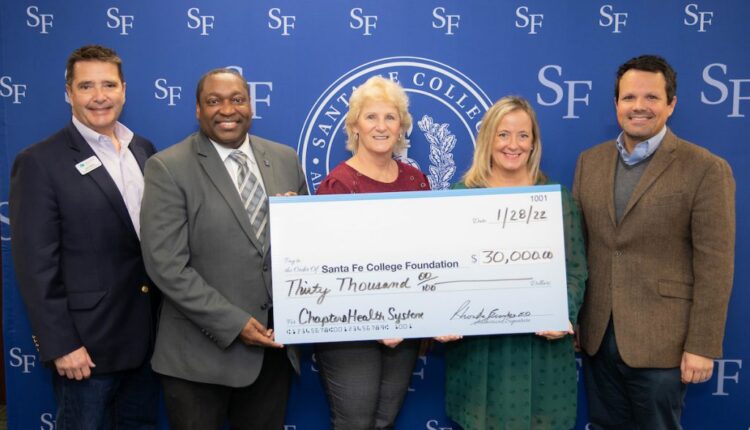 Santa Fe College President Paul Broadie, AVP for Advancement John Hooker stood with members of Chapters Health System with a grant check for $30,000