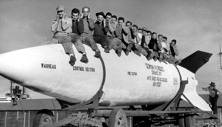 General Electric employees posing on a V-2 rocket at White Sands Proving Ground (now White Sands Missile Range) in New Mexico.