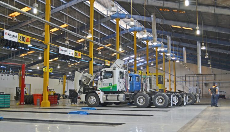 Trucks in mechanics bays for service; image by Carlos Daniel, via Unsplash.com.