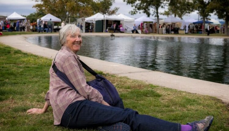Penny Duncklee takes a break on the grass by the duck pond at Young Park during a recent Renaissance Faire.
