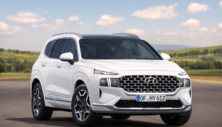     A white Hyundai Santa Fe parked outdoors. 