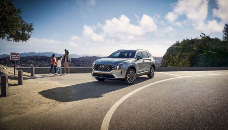 A silver gray 2023 Hyundai Santa Fe Plug-In Hybrid midsize crossover SUV model parked by a cliff overlook