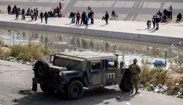Texas National Guard and Texas Department of Public Safety officers position themselves on the banks of the Rio Grande in El Paso on Dec. 20.