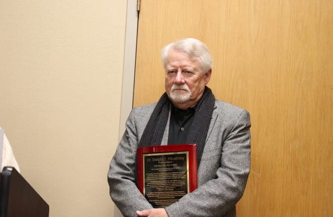 dr  Dwight T. Pitcaithley stands with a plaque honoring his induction into the Carlsbad Hall of Fame on Jan. 28, 2023.
