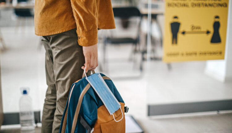 student with mask and backpack