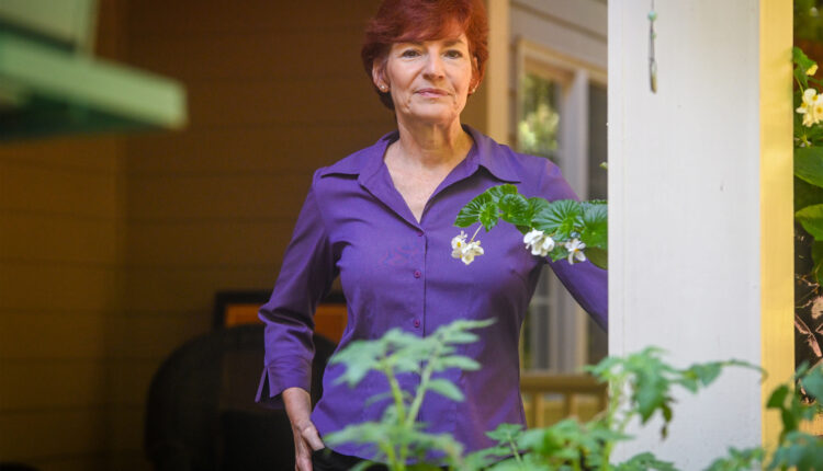 A photo of a woman posing for a portrait outside.