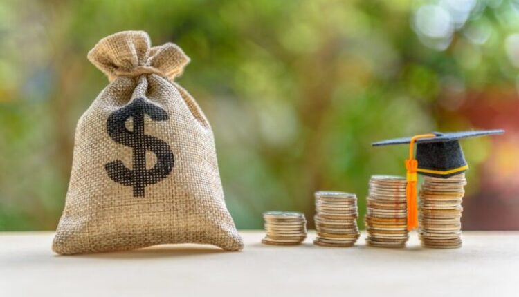 A burlap bag labeled with a dollar sign stands next to stacks of coins, one bearing a graduation cap.