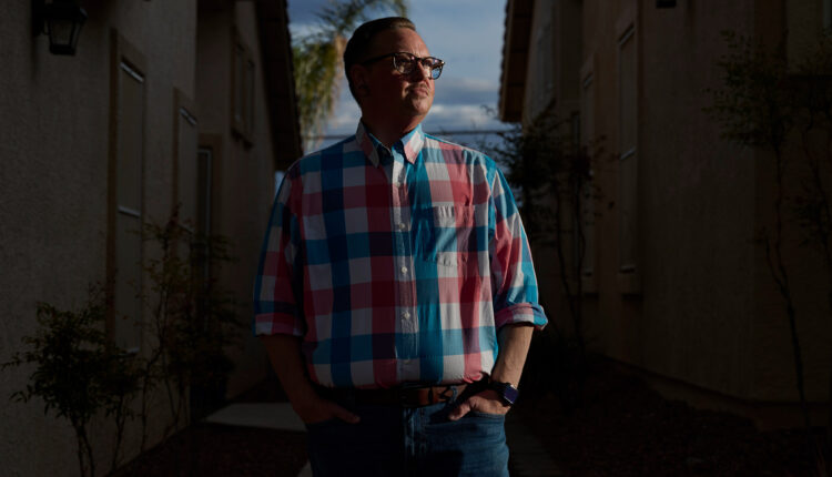 A photo of a man standing outside for a portrait with dramatic lighting.