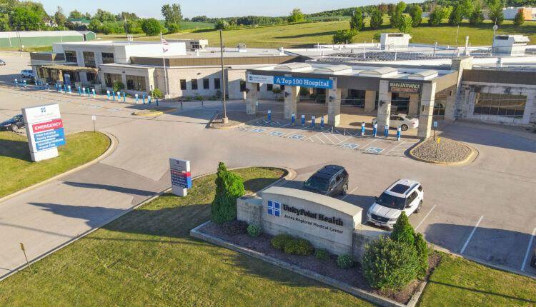 An aerial photo shows the entrance and front parking lot of a hospital.